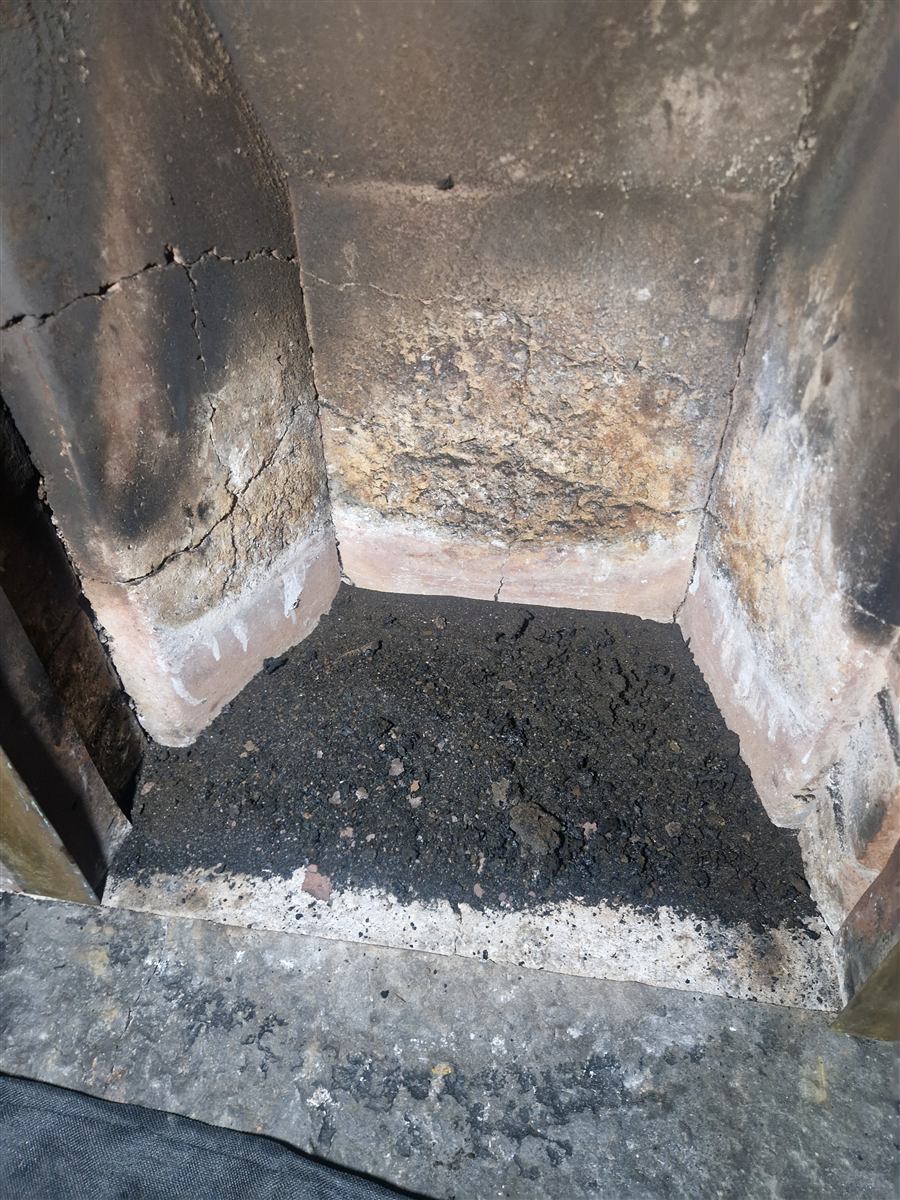 Heavy soot buildup inside a fireplace throat