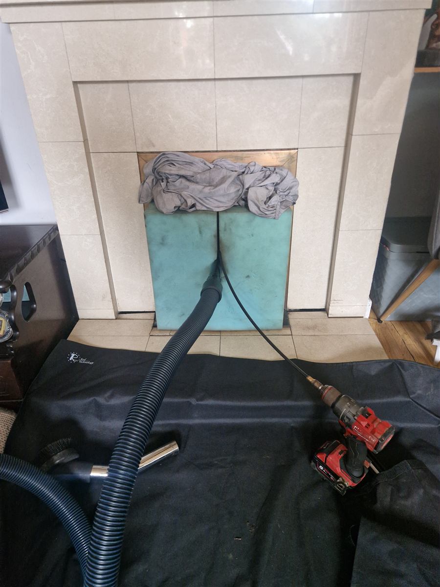 H-class vacuum extracting dust at a sealed fireplace